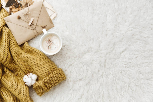 Cup of coffee, warm sweater and envelope. Flat lay composition. lazy morning, warm winter mood, blogger concept stock photo