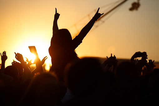 The crowd enjoys the summer music festival, sunset, the silhouettes hands up, Silhouette People Party Sunset Celebrate Dancing Concept