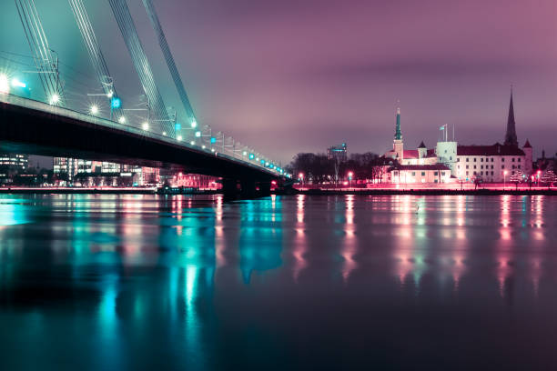 città vecchia e fiume daugava di notte, riga, lettonia - daugava river foto e immagini stock