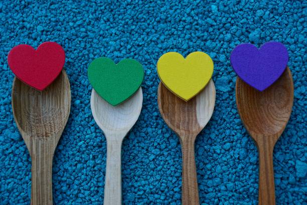 istock Wooden spoons with colored hearts on blue small stones 908550568
