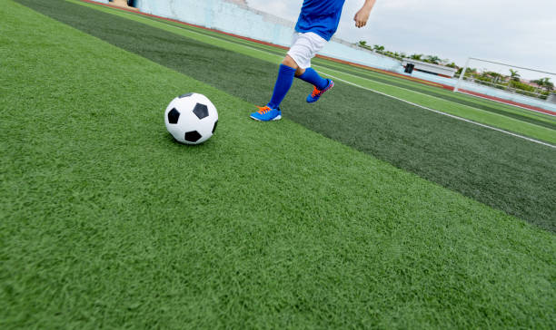 istock Young boy running after a soccer ball 908553820