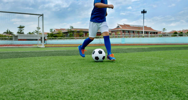 istock Young boy running after a soccer ball 908554010