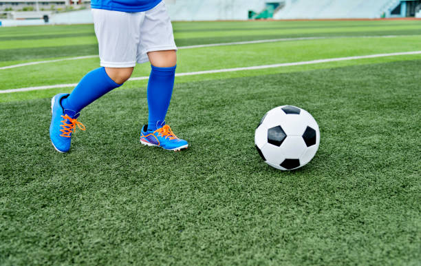 istock Young boy running after a soccer ball 908554110