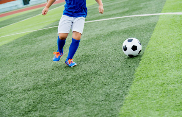 istock Young boy running after a soccer ball 908554188