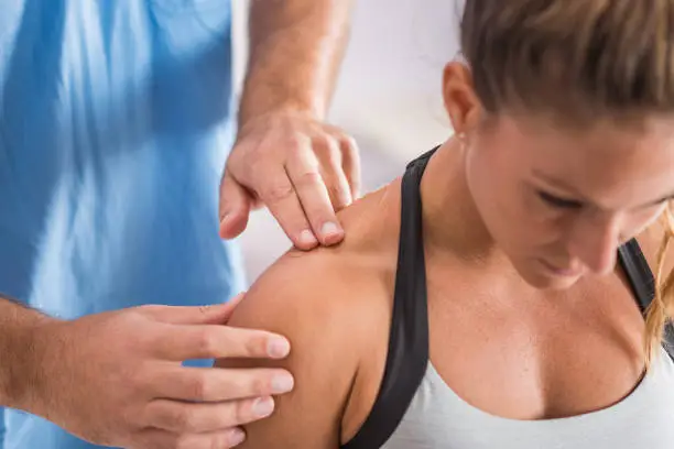 Photo of Physical therapy. Therapist addressing trapezius muscle