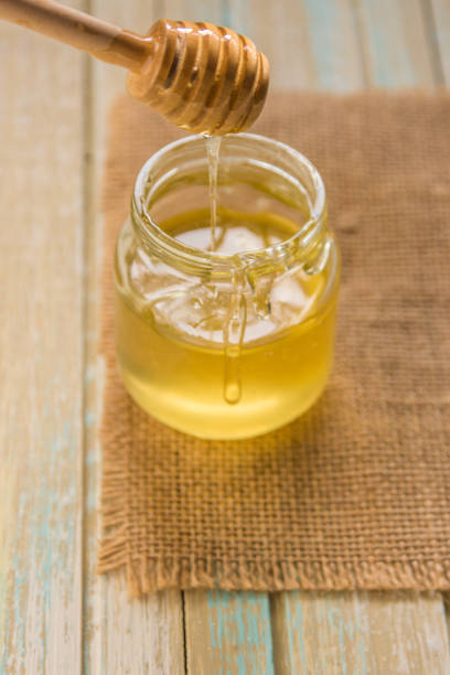 istock Honey pours with wooden sticks in a jar 908568358