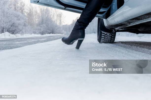 Routes In The Winter On The Road The White Car And The Girl Leg Stock Photo - Download Image Now