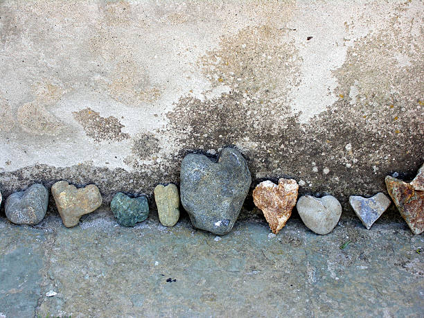 Row of colorful rocks shaped like hearts with big in middle stock photo