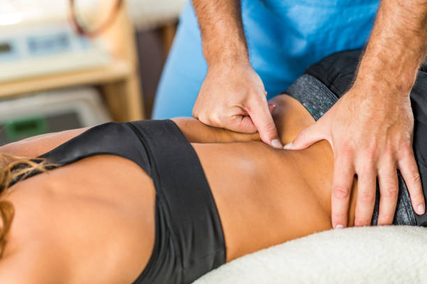 istock Osteopathy. Therapist applying strong pressure onto lower back muscles 908571514