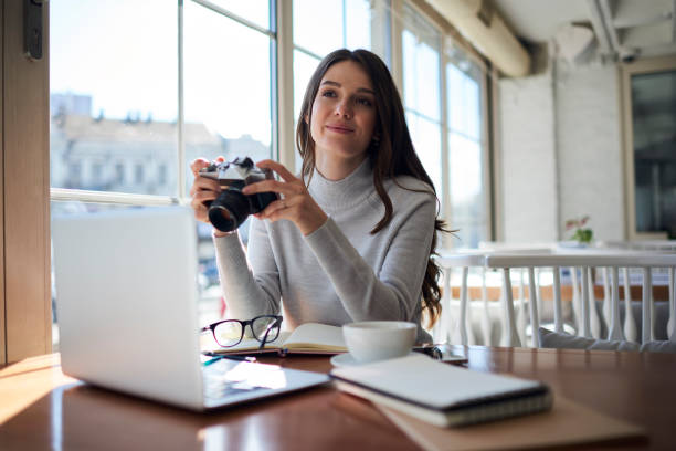 istock Young attractive female journalist testing work of vintage camera 908572450