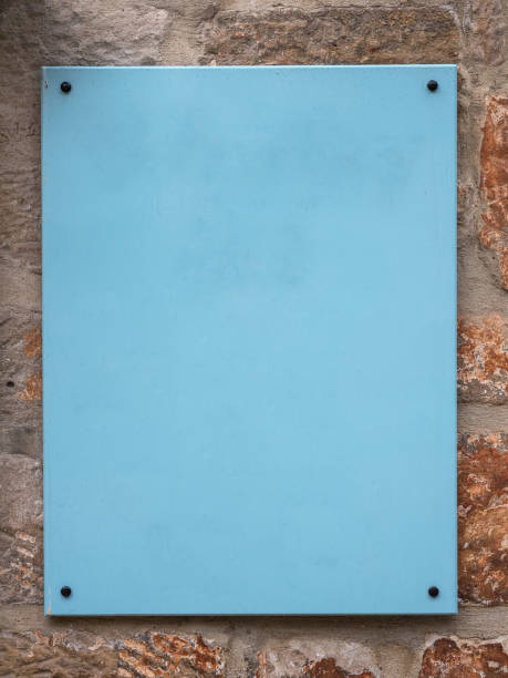istock Old blue sign or signboard on an old stone wall, fixed by bolts. 908575302