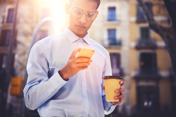 istock Young male internet user dressed in trendy outfit browsing websites 908578612