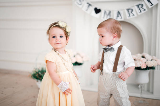 dois bebês casamento - garoto e garota vestida de noiva e noivo - baby toddler child flower - fotografias e filmes do acervo