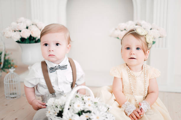 istock two babies wedding - boy and girl dressed as bride and groom 908581566