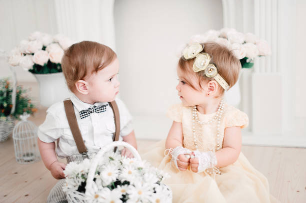 istock two babies wedding - boy and girl dressed as bride and groom 908581568