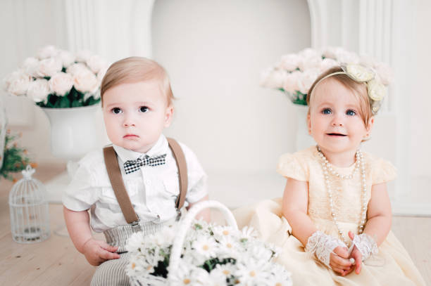 istock two babies wedding - boy and girl dressed as bride and groom 908581570