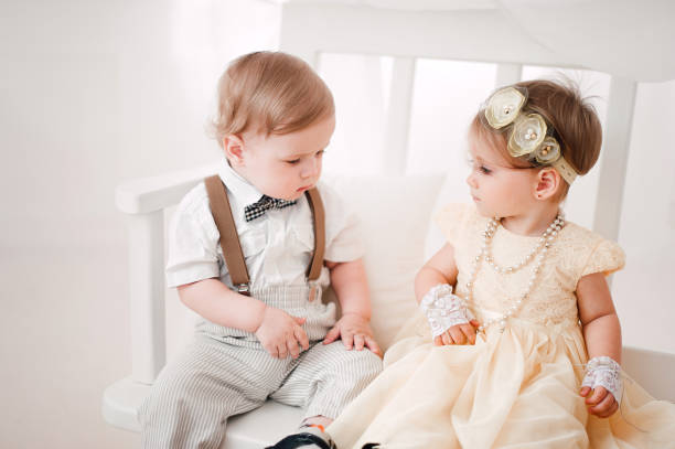 istock two babies wedding - boy and girl dressed as bride and groom 908581626