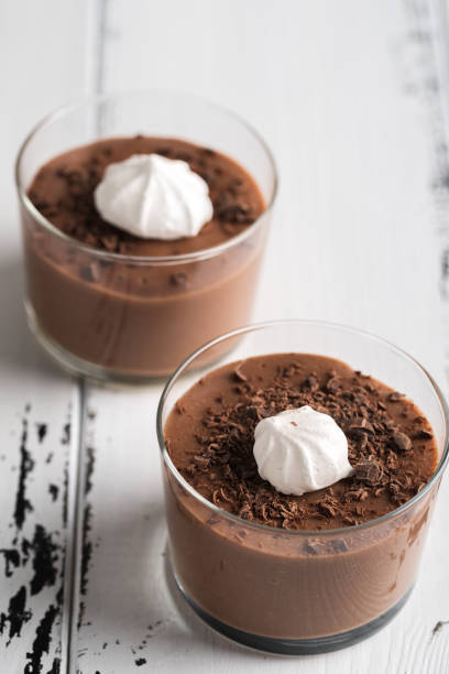 istock Chocolate mousse in a glasses on a white wood background. 908582092