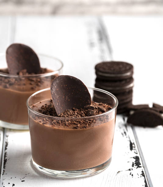 istock Chocolate mousse in a glasses on a white wood background. 908582112