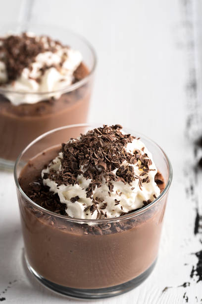 istock Chocolate mousse in a glasses on a white wood background. 908582150