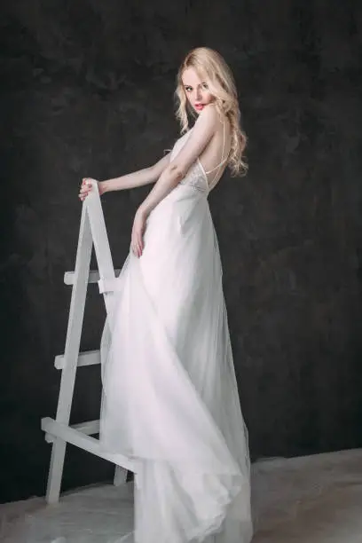 Photo of Portrait of a beautiful blond girl in image of the bride . Beauty face. Photo shot in the Studio on a grey background