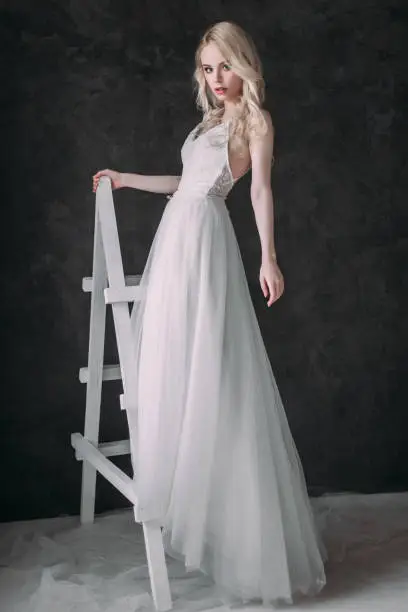 Photo of Portrait of a beautiful blond girl in image of the bride . Beauty face. Photo shot in the Studio on a grey background