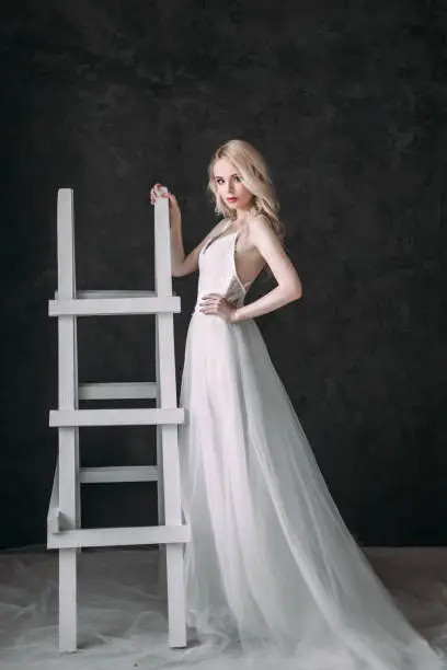 Photo of Portrait of a beautiful blond girl in image of the bride . Beauty face. Photo shot in the Studio on a grey background