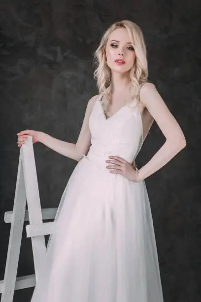 Photo of Portrait of a beautiful blond girl in image of the bride . Beauty face. Photo shot in the Studio on a grey background