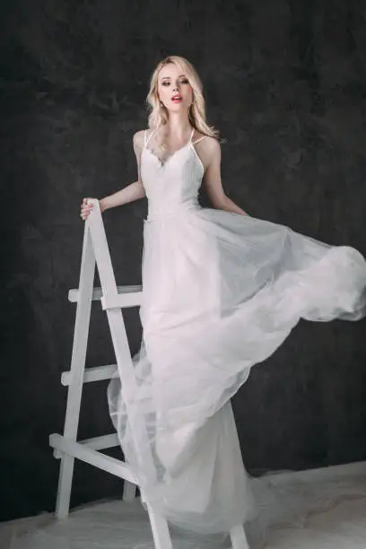 Photo of Portrait of a beautiful blond girl in image of the bride . Beauty face. Photo shot in the Studio on a grey background