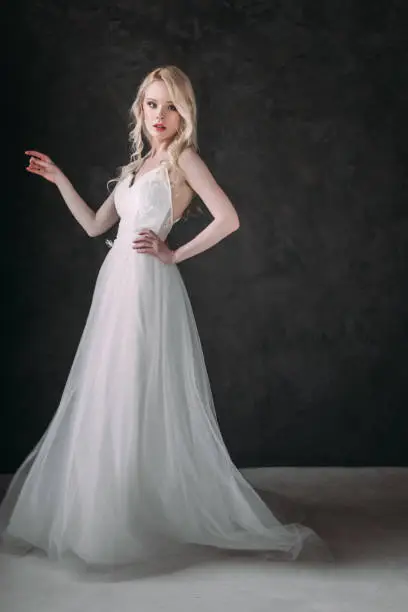 Photo of Portrait of a beautiful blond girl in image of the bride . Beauty face. Photo shot in the Studio on a grey background