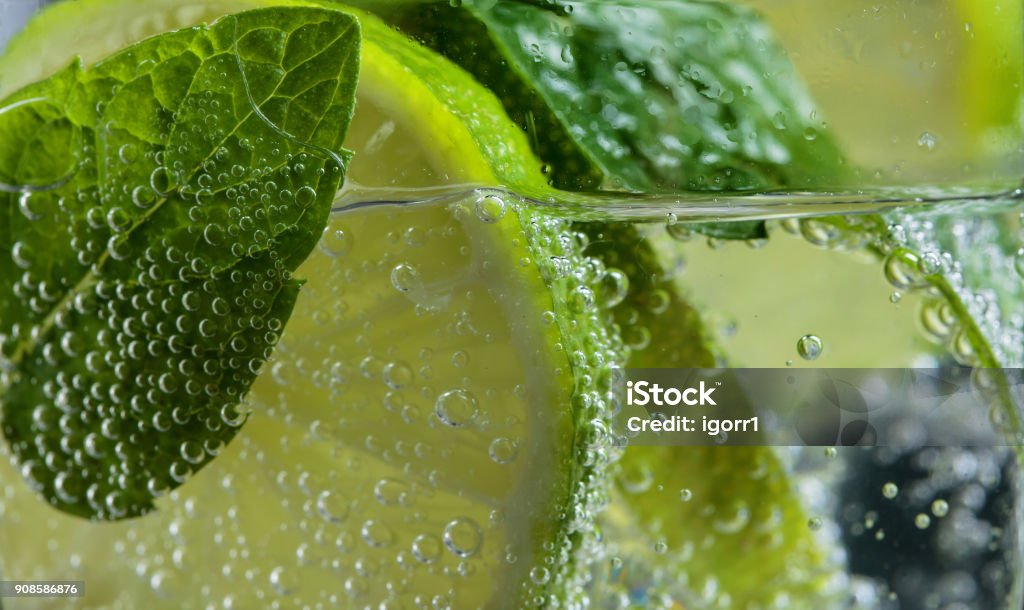 Close up of cocktail with lime , ice  and mint  . Close up of cocktail with lime , ice  and mint leaves . Water Stock Photo
