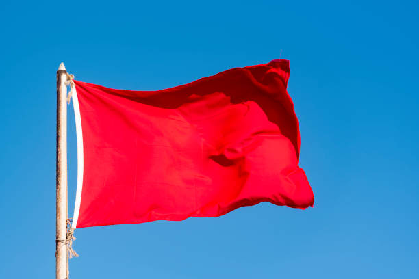 Red flag on the beach as warning for tourists for don't swim.
