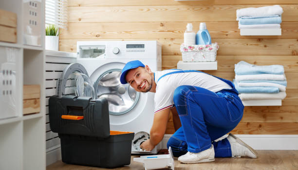 istock working man   plumber repairs  washing machine in   laundry 908590216