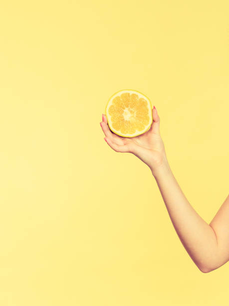 istock Woman hand holding green grape fruit slice 908593110