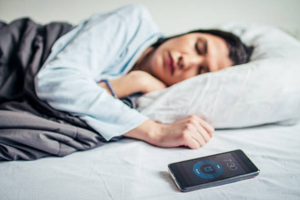 istock Woman Sleeping On Bed With Alarm On Mobile Phone 908604246