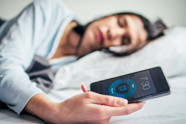 istock Woman Sleeping On Bed With Alarm On Mobile Phone 908604314