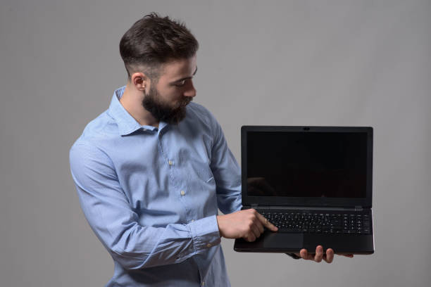 istock Young confident business man or programmer using computer and watching laptop monitor 908604930