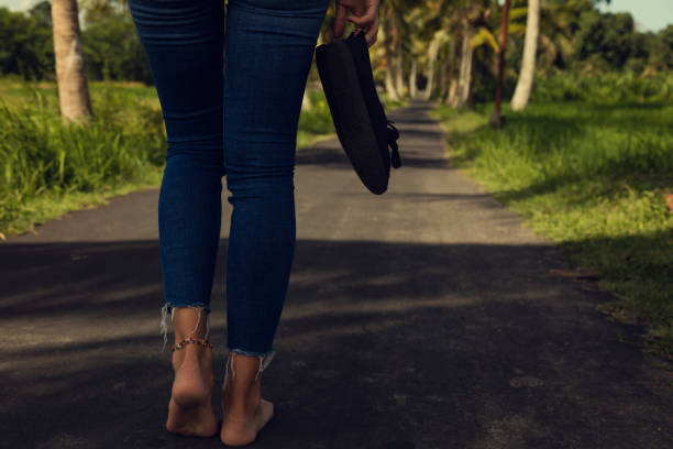 Women's beautiful legs with canvas shoes on the road.