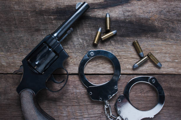 istock Gun with ammunition and shackle on wood background, Top view 908610832