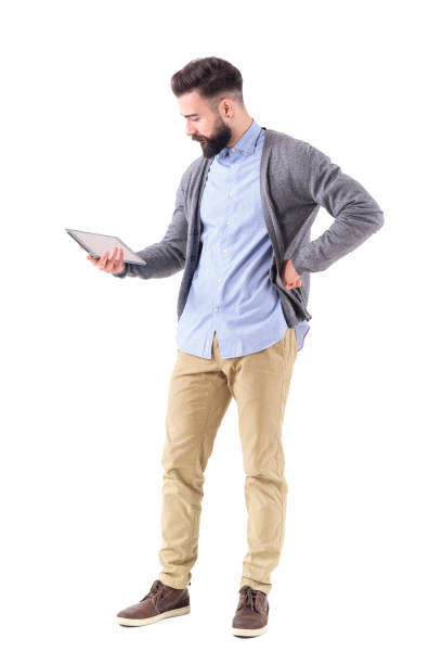 istock Attractive young bearded modern businessman holding and watching and tablet computer. 908610952