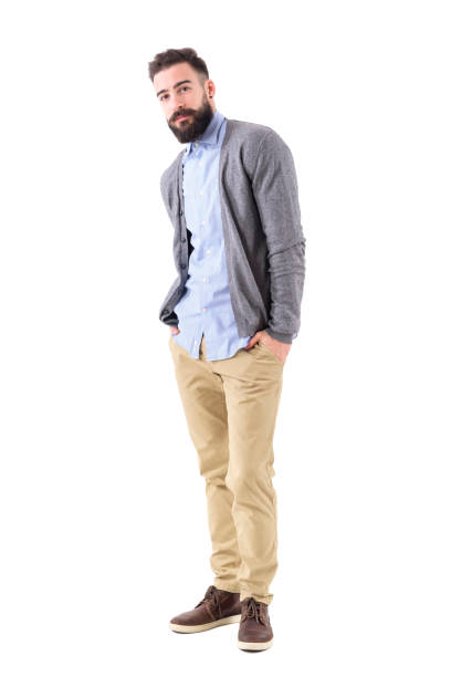 istock Handsome hipster in smart casual clothes posing tilted with hands in pockets 908611356