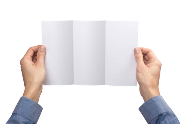 istock Mockup flaeth folded three times empty blank white holds the man in his hand in shirt. Isolated on a white background 908614594