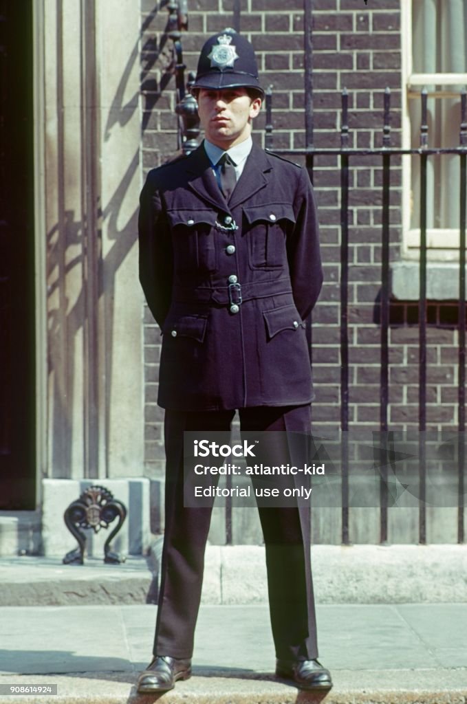 Police officer, London London, England, UK, 1977. London police officer in front of a house facade. Police Force Stock Photo