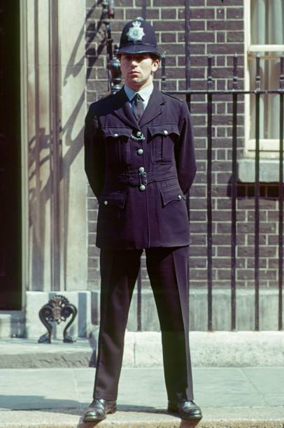 Police officer, London London, England, UK, 1977. London police officer in front of a house facade. metropolitan police stock pictures, royalty-free photos & images