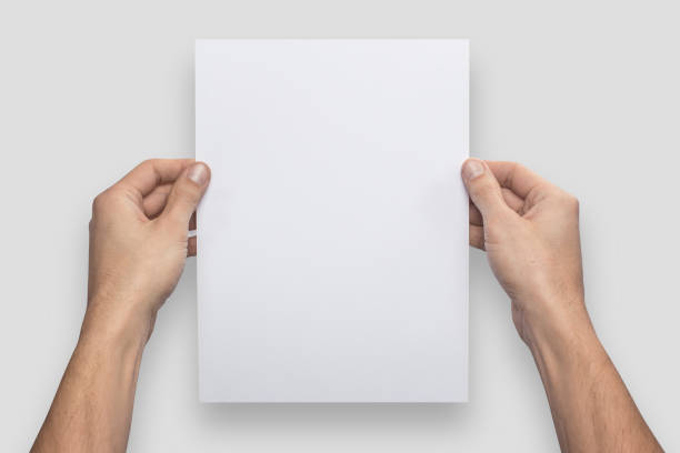 istock Mockup A4 letter vertical empty blank white holds the man in his hand. Isolated on a gray background 908617724