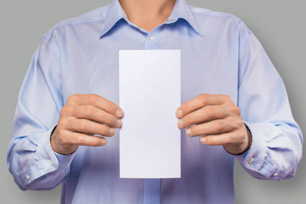 istock The men in the shirt are holding an empty white flyer. Mockup, template 908618120