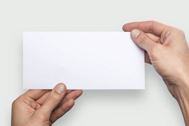 istock Mockup horizontal flyer empty blank white holds the man in his hand. Isolated on a gray background 908618160