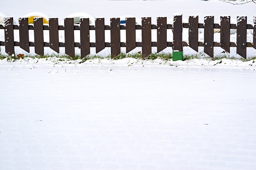 small wooden the fence closup is covered with snow and a blank space for the text on snow in the winter