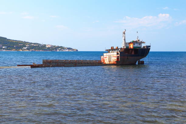 Unknown semi-submerged rusted and destroyed barge stranded in a bay on the Black Sea. Kabardinka, Krasnodar region, Russia