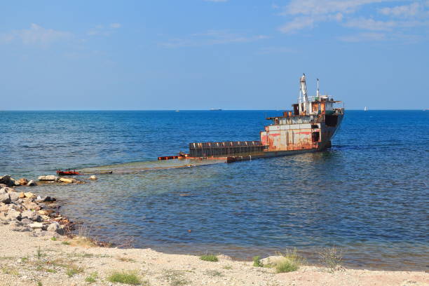 istock Unknown semi-submerged rusted and destroyed barge stranded in a bay 908635614